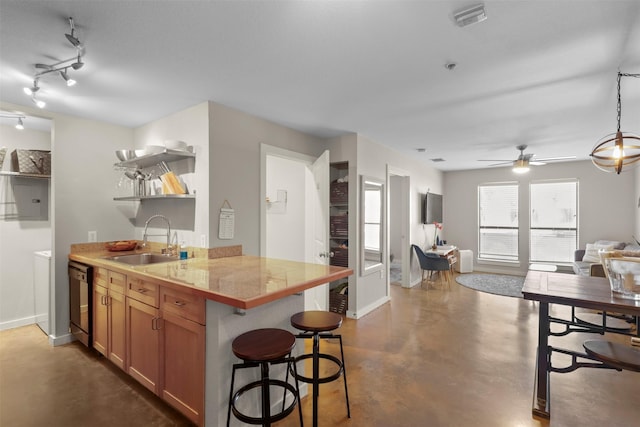 kitchen with sink, dishwasher, kitchen peninsula, and a breakfast bar area