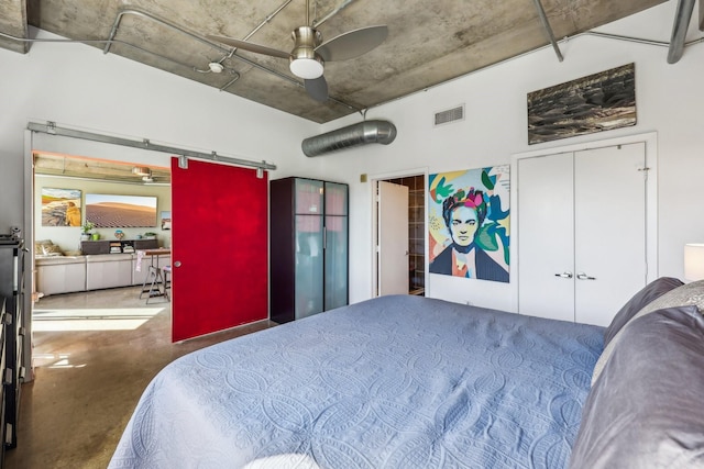 bedroom featuring ceiling fan, a closet, and a barn door