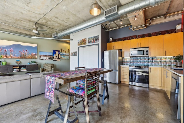 kitchen with sink, tasteful backsplash, ceiling fan, and appliances with stainless steel finishes