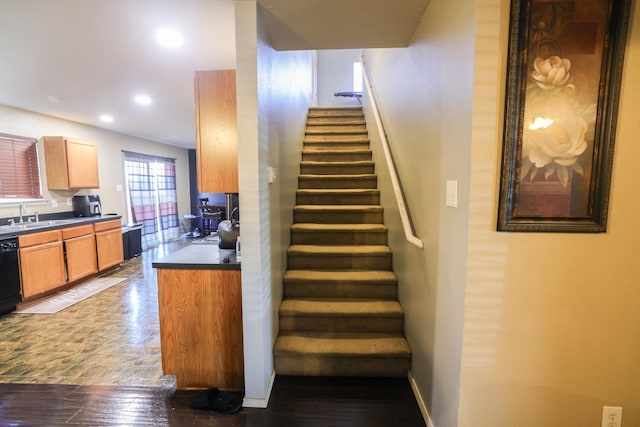 staircase featuring sink and hardwood / wood-style flooring