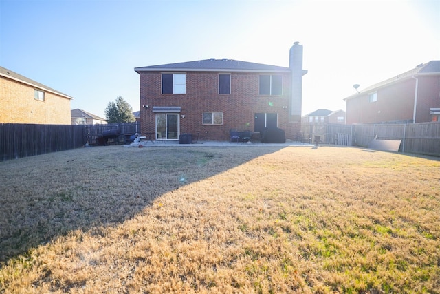 rear view of property with a lawn and a patio