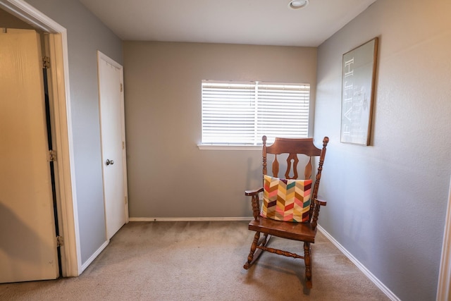 living area featuring light carpet