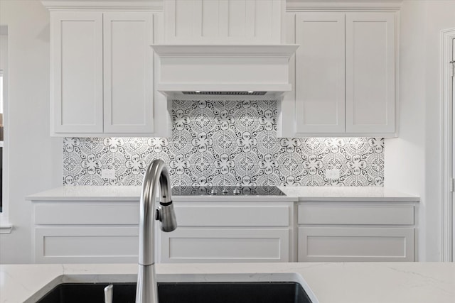 kitchen featuring white cabinetry, sink, backsplash, and premium range hood