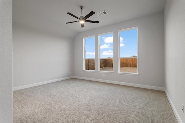 empty room with ceiling fan, light colored carpet, and lofted ceiling