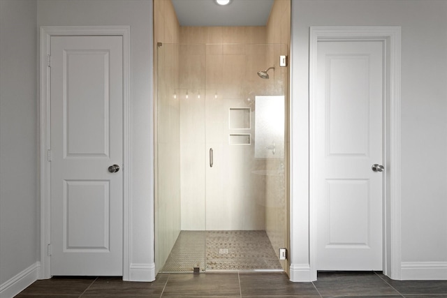 bathroom featuring a shower with door and tile patterned flooring