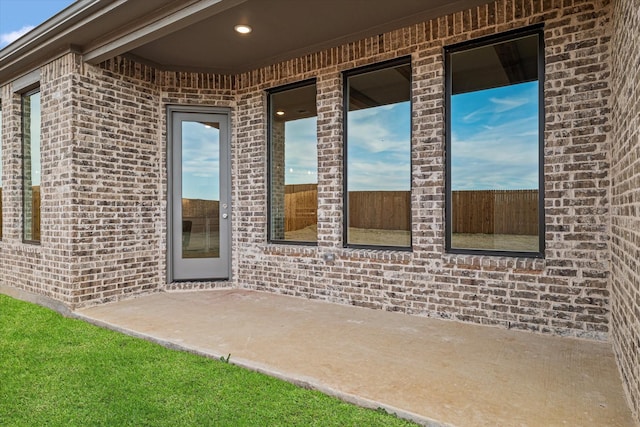 view of exterior entry with a patio area