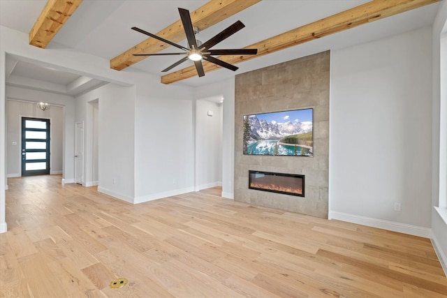 unfurnished living room with a fireplace, light wood-type flooring, beam ceiling, and ceiling fan