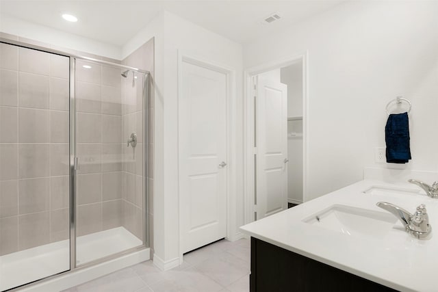 bathroom with tile patterned floors, a shower with door, and vanity