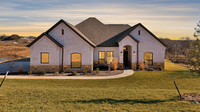 french country style house featuring a lawn