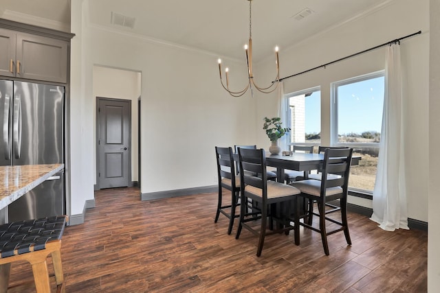 dining space featuring an inviting chandelier, crown molding, and dark hardwood / wood-style flooring