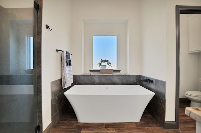 bathroom with independent shower and bath, toilet, and tile walls