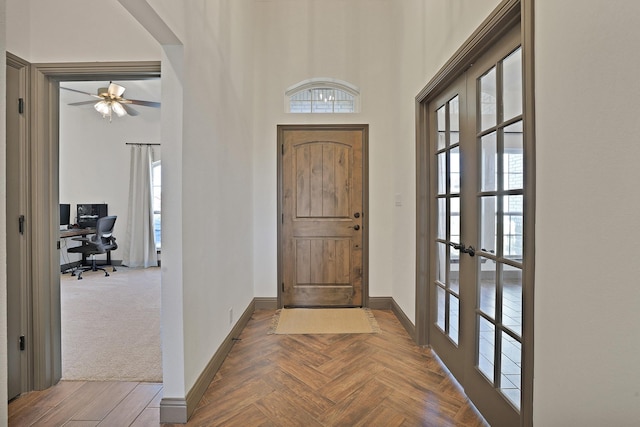 foyer featuring a towering ceiling and baseboards