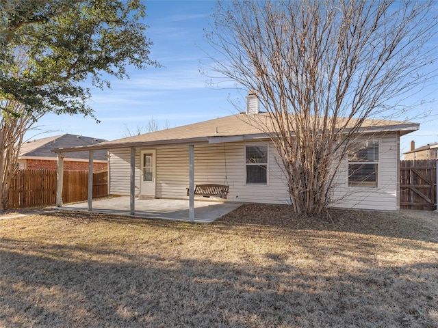 back of property with a patio area and a lawn