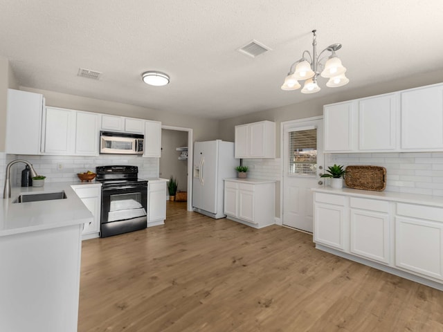 kitchen with sink, decorative light fixtures, black / electric stove, white cabinetry, and white fridge with ice dispenser