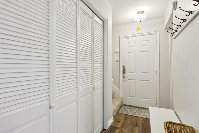 doorway featuring a textured ceiling and dark hardwood / wood-style flooring