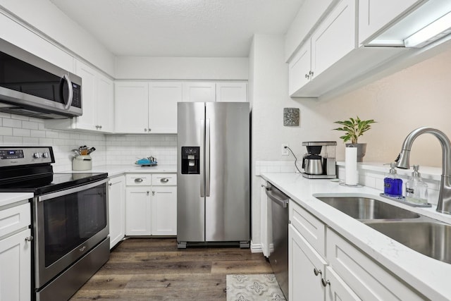 kitchen featuring dark hardwood / wood-style flooring, sink, white cabinetry, a textured ceiling, and stainless steel appliances