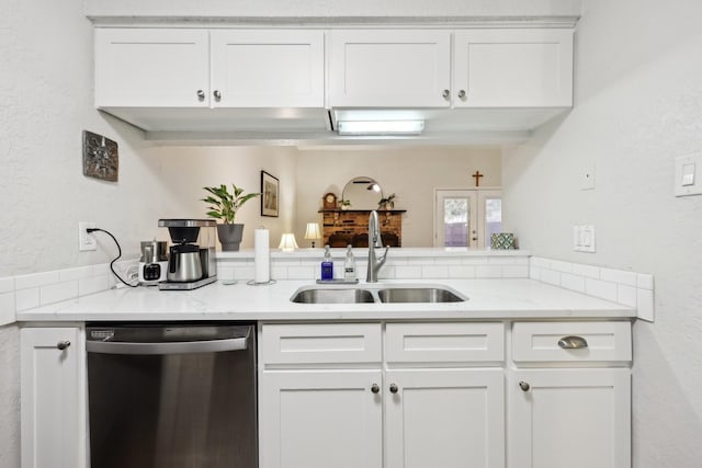 kitchen featuring light stone counters, sink, white cabinetry, and stainless steel dishwasher