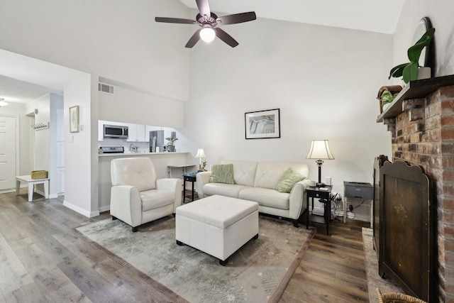 living room with ceiling fan, a brick fireplace, dark hardwood / wood-style floors, and lofted ceiling