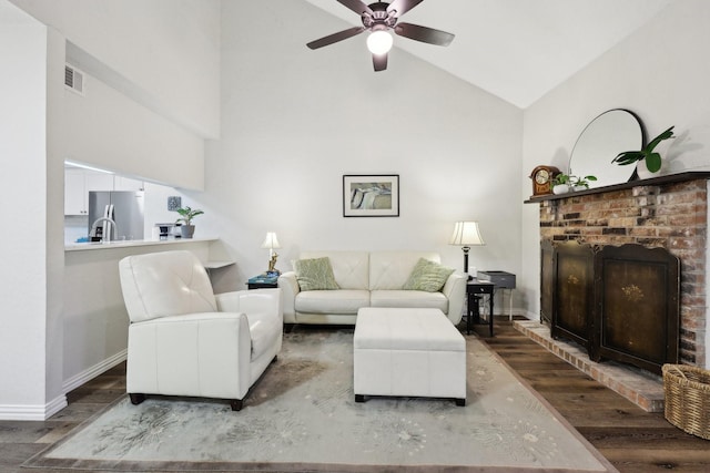 living room featuring ceiling fan, hardwood / wood-style floors, vaulted ceiling, and a fireplace