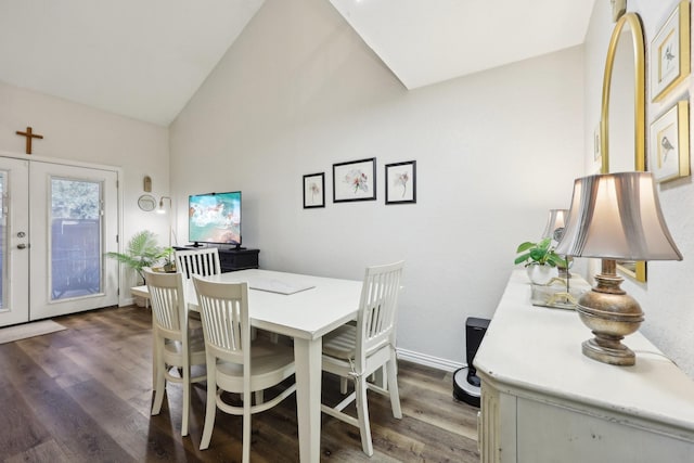 dining area with dark wood-type flooring, lofted ceiling, and french doors