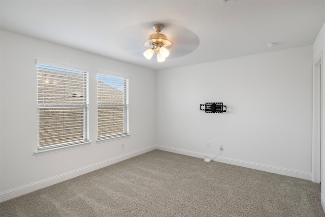 unfurnished room featuring ceiling fan and carpet