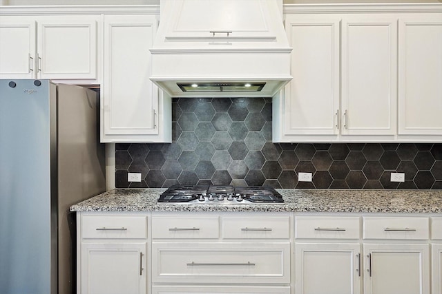 kitchen with white cabinets, backsplash, and appliances with stainless steel finishes