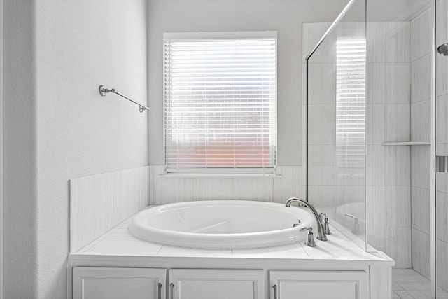 bathroom with independent shower and bath and a wealth of natural light