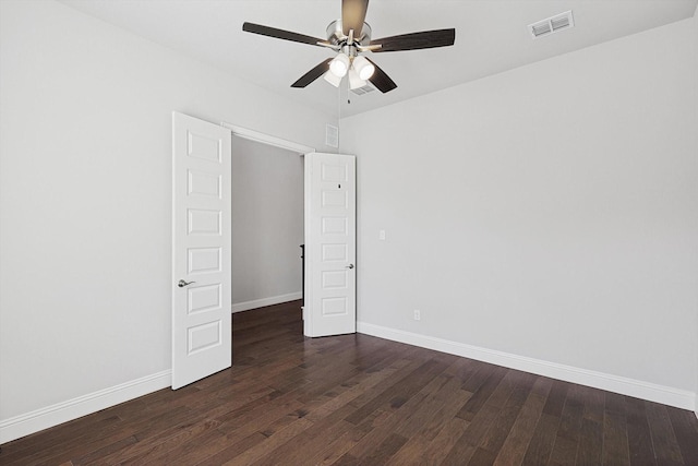 empty room with ceiling fan and dark wood-type flooring