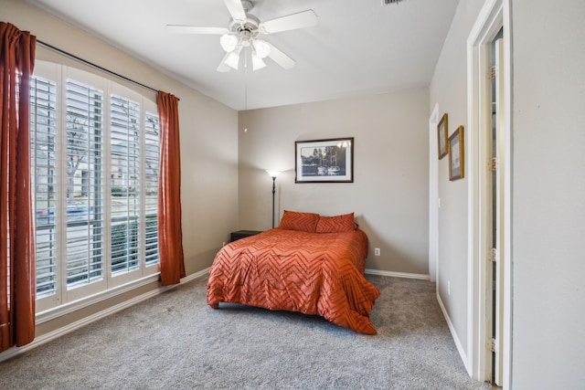 carpeted bedroom with ceiling fan and multiple windows