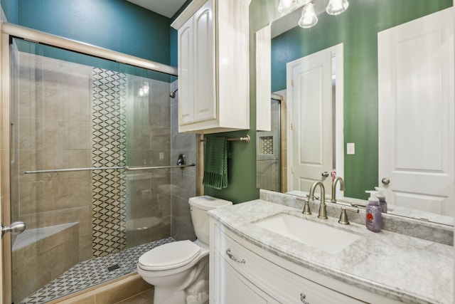 bathroom featuring toilet, an enclosed shower, and vanity