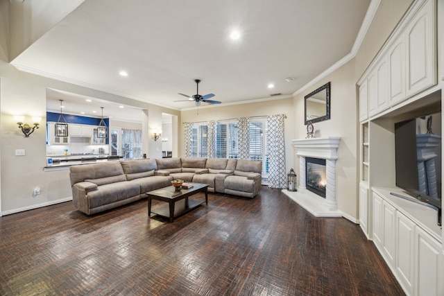 living room featuring ceiling fan, dark hardwood / wood-style flooring, and ornamental molding