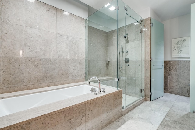 bathroom featuring independent shower and bath and tile walls