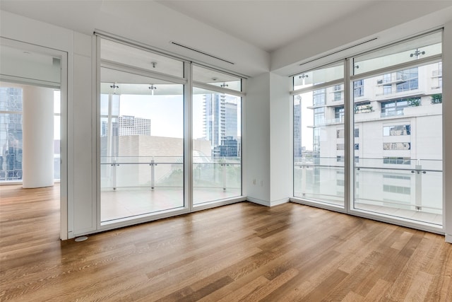 doorway to outside featuring light wood-type flooring and floor to ceiling windows