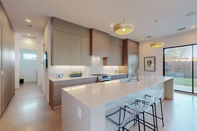 kitchen with a large island, sink, pendant lighting, a breakfast bar, and appliances with stainless steel finishes