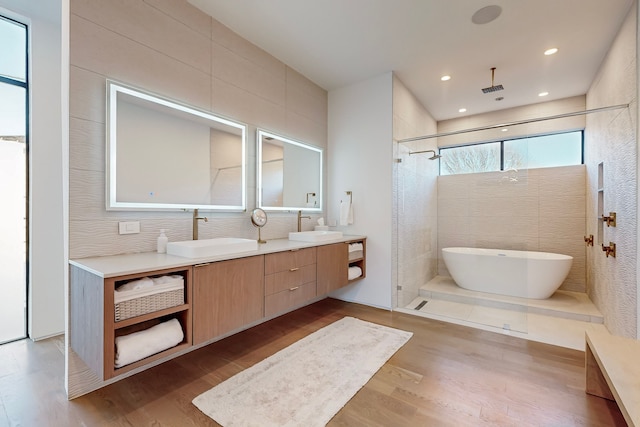 bathroom with vanity, wood-type flooring, independent shower and bath, and tile walls