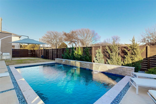 view of swimming pool with pool water feature, area for grilling, and a patio