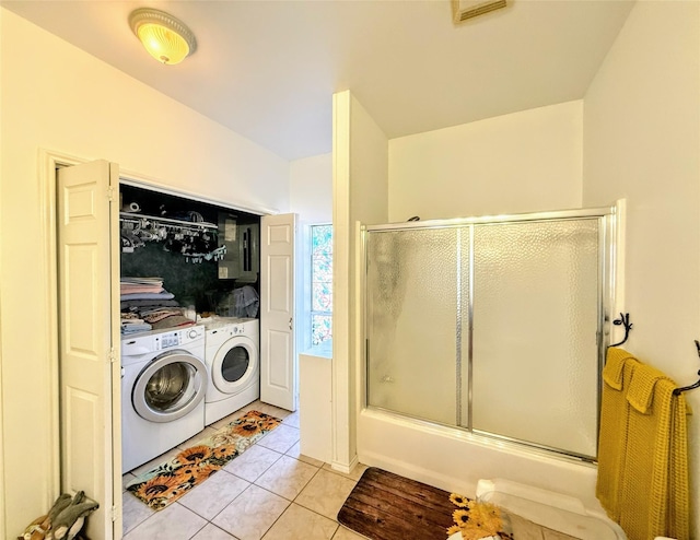 clothes washing area with light tile patterned floors and independent washer and dryer