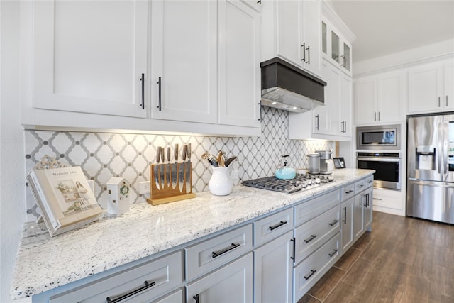 kitchen with dark hardwood / wood-style floors, tasteful backsplash, white cabinetry, stainless steel appliances, and custom range hood