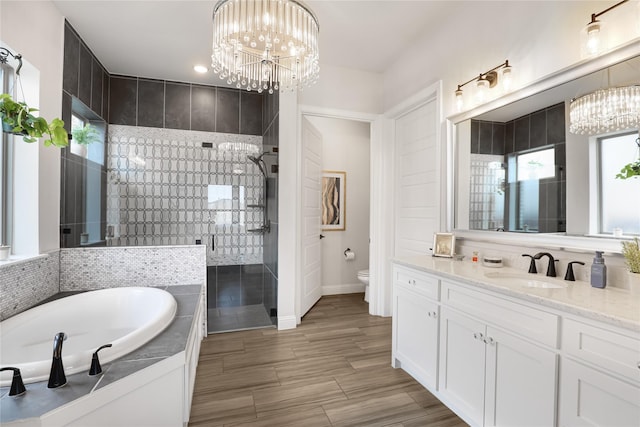 full bathroom with vanity, shower with separate bathtub, an inviting chandelier, and toilet