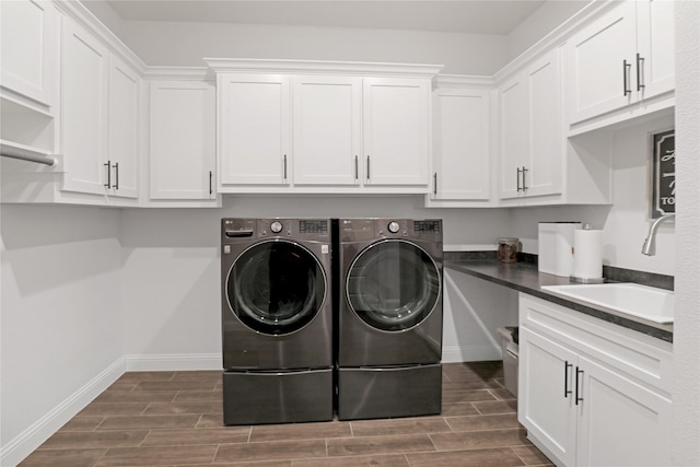 clothes washing area featuring cabinets, sink, and washing machine and dryer