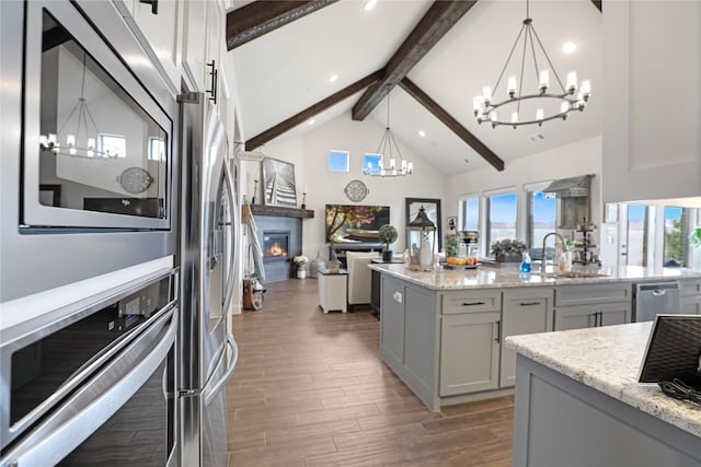 kitchen with sink, decorative light fixtures, gray cabinets, a notable chandelier, and stainless steel appliances