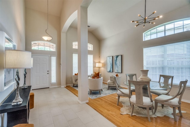 entrance foyer with a towering ceiling, an inviting chandelier, and light hardwood / wood-style floors