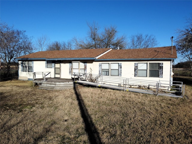 rear view of property with a wooden deck and a yard