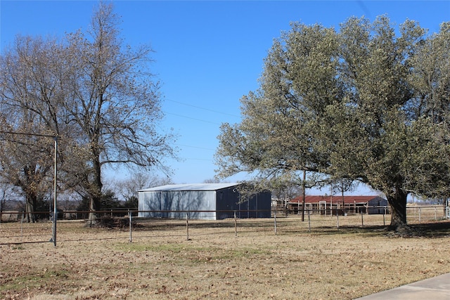 view of yard with an outdoor structure and a rural view