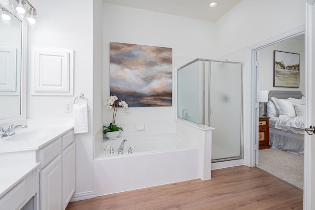 bathroom featuring wood-type flooring, plus walk in shower, and vanity