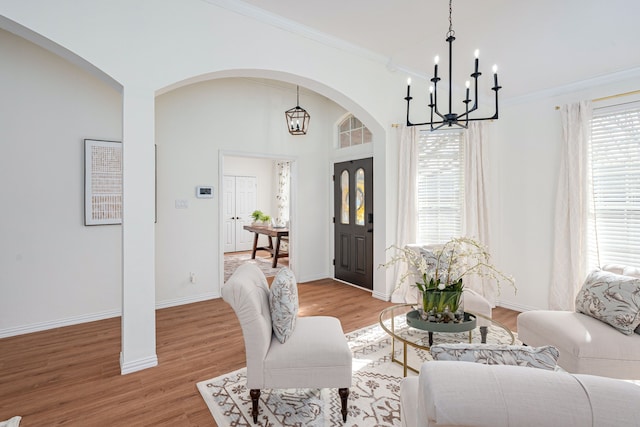 interior space featuring light hardwood / wood-style floors, crown molding, and a chandelier