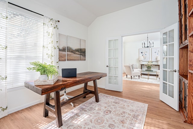 office space featuring light wood-type flooring, a notable chandelier, lofted ceiling, and french doors