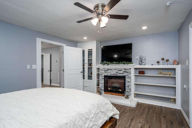 bedroom featuring ceiling fan, dark hardwood / wood-style floors, and a textured ceiling