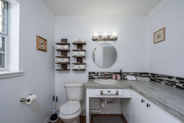 bathroom with tasteful backsplash, sink, and toilet