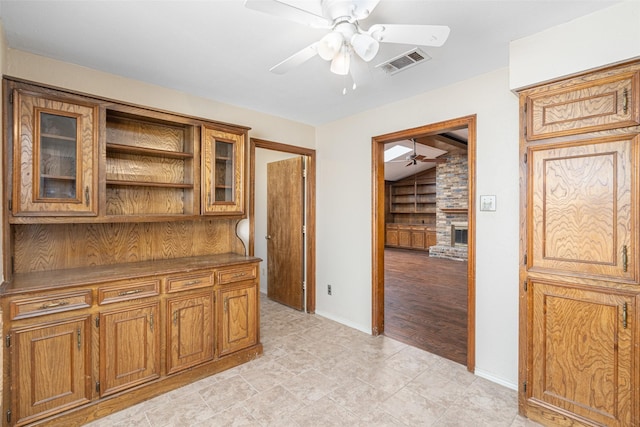 interior space with ceiling fan and a large fireplace